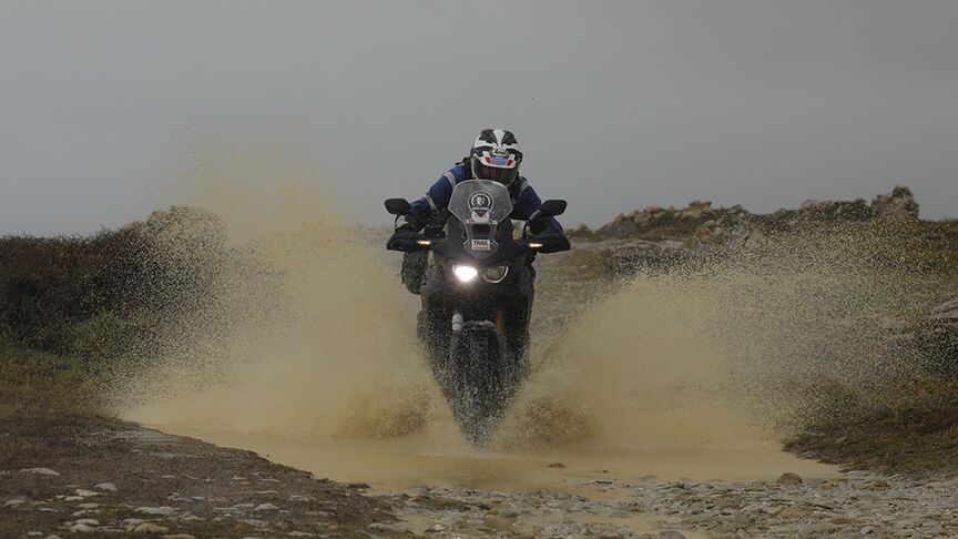 Motorradfahrer unterwegs auf unwegsamem Terrain in Südafrika.