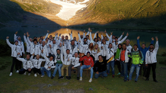 Os participantes na Honda Adventure Roads celebram junto à água ao pôr do sol.