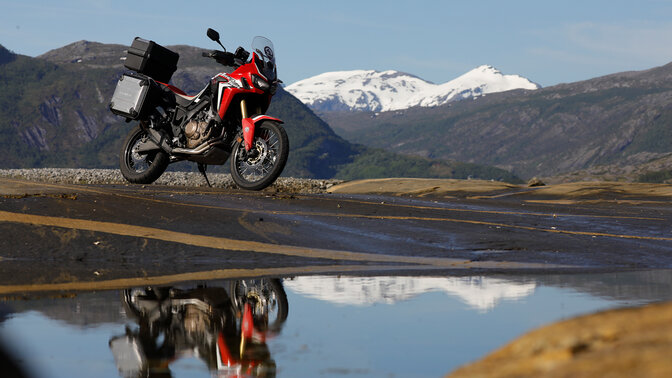 Africa Twin parked next to fast flowing river in Norway