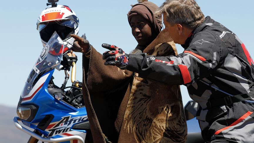 Motorrijder rijdend door de ruwe terreinen van Zuid-Afrika.