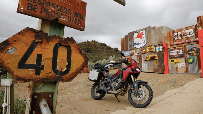 Honda CRF1000L Africa Twin estacionada en una gasolinera de carretera.