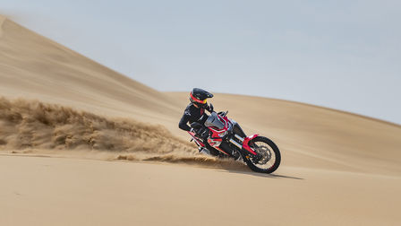 Motocykl Honda Africa Twin při jízdě v poušti.