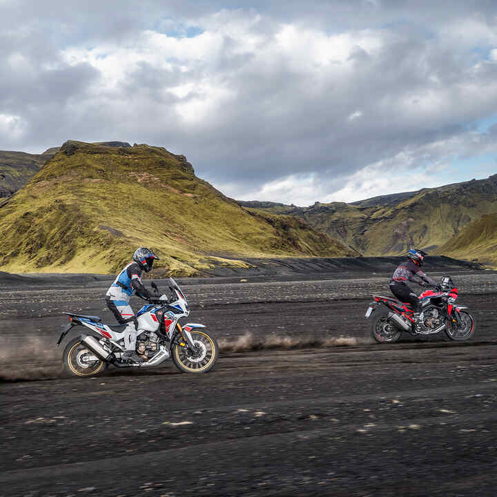 Deux pilotes sur une moto Honda Africa Twin roulant hors route.