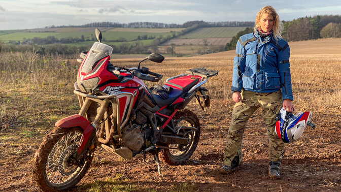 Vanessa Ruck in piedi accanto a una Honda Africa Twin. 