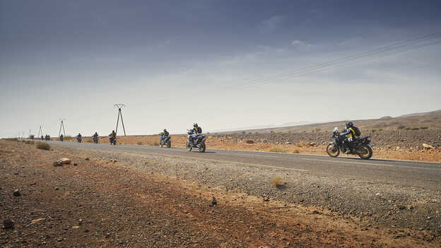 Jazdci na motocykloch Honda Africa Twin v Maroku na asfaltovej ceste.